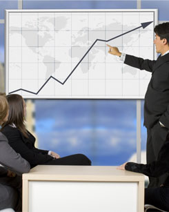 Imagen de un asesor explicando una gráfica evolutiva del mercado.